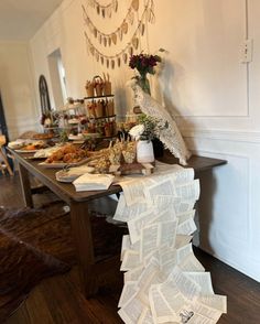 the table is covered with many papers and flowers in vases on top of it