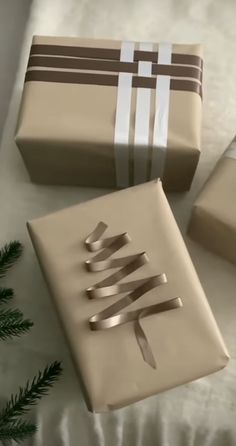 three wrapped presents sitting on top of a bed