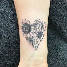 a small sunflower tattoo on the ankle with words written in cursive font