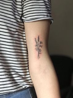 a woman's arm with a flower tattoo on the left side of her arm