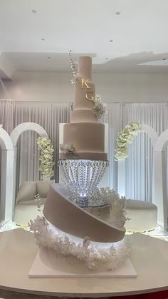 a wedding cake is on display in the middle of a room with white drapes