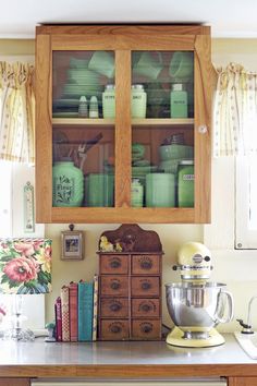 a wooden cabinet filled with lots of green dishes