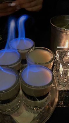 several candles are lit on a plate with ice cubes in front of the candle holders