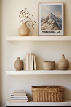 three white shelves with vases and books on them