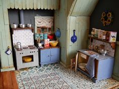 a doll house kitchen with an oven, stove and sink