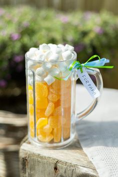 a glass mug filled with marshmallows on top of a table