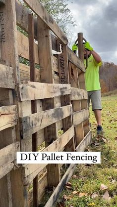 a man standing next to a wooden fence with the words diy pallet fencing on it