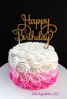 a birthday cake with pink and white frosting on top that says happy birthday written in gold