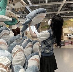 a woman is looking at stuffed animals in a store