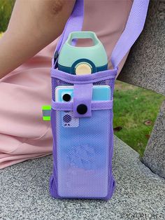 a person sitting on a bench holding a purple bag with a cell phone in it