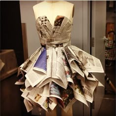 a dress made out of newspapers sitting on top of a mannequin