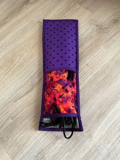 an open purple case with polka dots on the side and a colorful fabric inside it