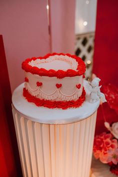 a red and white wedding cake sitting on top of a table