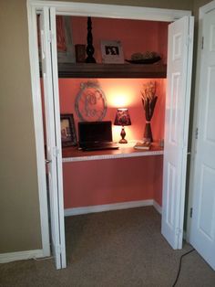 an open closet with a laptop on the desk