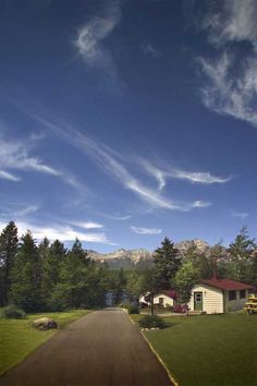 an artist's rendering of a house in the middle of a road with mountains in the background