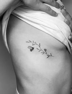 a woman's stomach with flowers and leaves on the side, in black and white