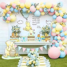 a winnie the pooh birthday party with balloons and dessert table set up on grass