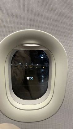 an airplane window with a person looking out the window