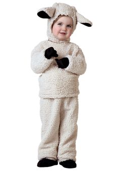 a little boy in a sheep costume standing with his arms crossed and smiling at the camera