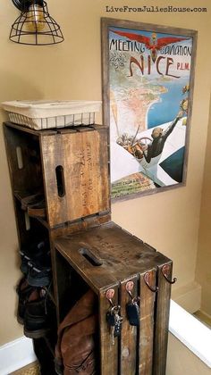 an old suitcase is sitting on top of a wooden cabinet in front of a poster