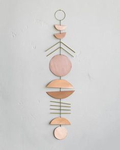 a metal wall hanging with various shapes and colors on the outside, including circulars