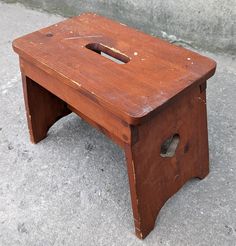 an old wooden step stool with holes in it