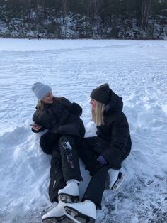 two women sitting in the snow talking