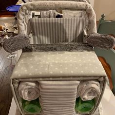 a diaper bag sitting on top of a wooden table next to a baby seat