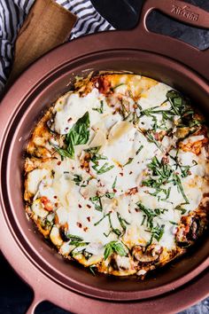 a pizza with cheese and herbs in a pan