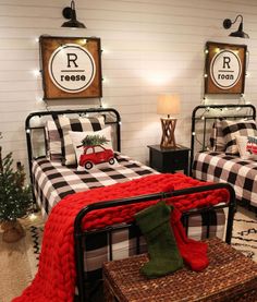 two beds in a room with christmas decorations on the wall and plaid bedding,