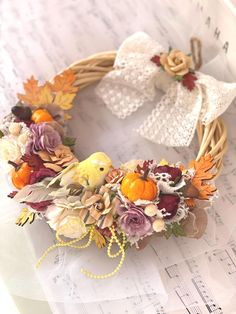 a wreath made out of flowers and leaves on sheet music paper with an ornament