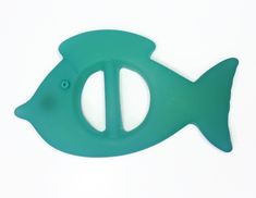 a green plastic fish shaped object on a white surface