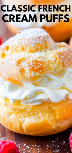 a close up of a pastry with whipped cream on top and raspberries in the background