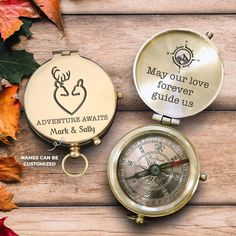 two personalized pocket watches sitting next to each other on a wooden surface with autumn leaves