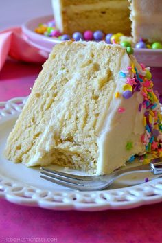 a piece of cake on a plate with a fork next to it and another slice in the background