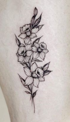 a black and white flower tattoo on the thigh