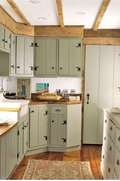 a kitchen with lots of cupboards and a rug on the floor in front of it