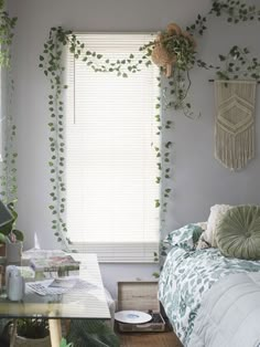 a bedroom with plants on the wall and a bed in front of a large window