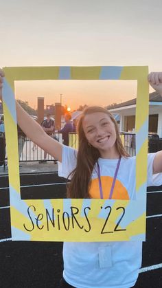 a girl holding up a sign that says seniors 22