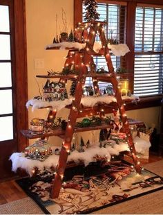 a christmas tree made out of wooden ladders with lights and ornaments on the top