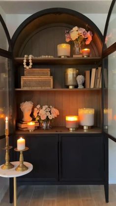 a shelf with candles and flowers on it