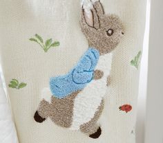 a close up of a sweater with a rabbit on it's back and an insect embroidered on the side