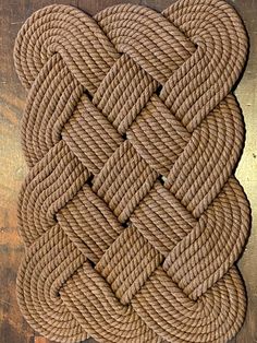 a rope on top of a wooden table next to a metal plate with a knot in the middle