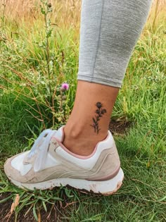 a woman's foot with a small flower tattoo on her left ankle and right leg