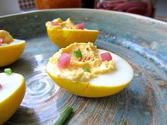 deviled eggs with celery and mayonnaise on a blue platter