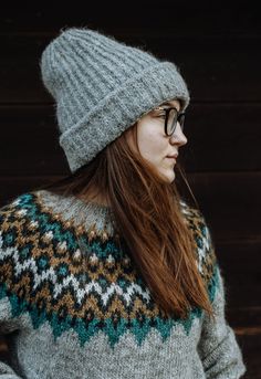 a woman with long hair wearing a hat and sweater