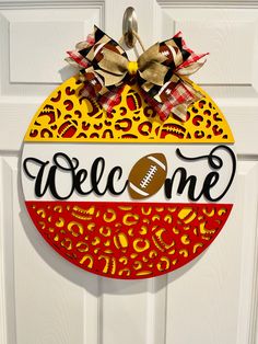 a door hanger that says welcome with a football and leopard print design on it