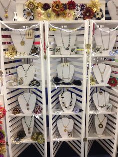 a white display case filled with lots of necklaces