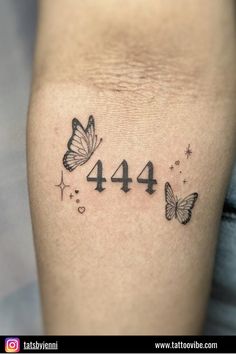 a tattoo with butterflies and numbers on the side of her leg that reads 4 44