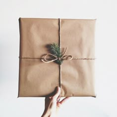 a person holding a wrapped present with the words it's almost here